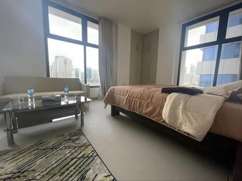 阿布扎比Heart of Abu Dhabi - Adorable Master Room的卧室配有床、桌子和窗户。