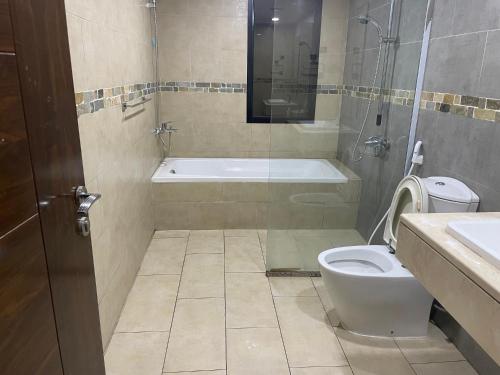 阿布扎比Heart of Abu Dhabi - Luxury Room的浴室配有卫生间、浴缸和水槽。