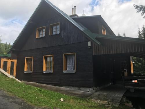 霍尔尼米瑟克基chata Školička的黑房子,有 ⁇ 帽屋顶