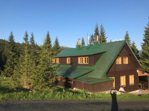 霍尔尼米瑟克基chata Školička的一座带绿色屋顶的大型木制房屋