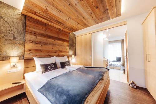 塞博登Pension Linder的一间卧室设有一张带木墙的大床