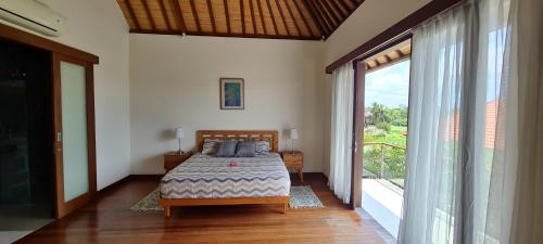 海神庙Villa Dimaya的一间卧室设有一张床和一个大窗户