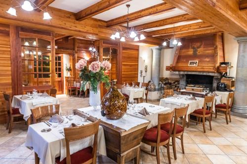 巴拉迪亚Hotel-Restaurant Spa Les Peupliers的餐厅设有白色的桌椅和壁炉