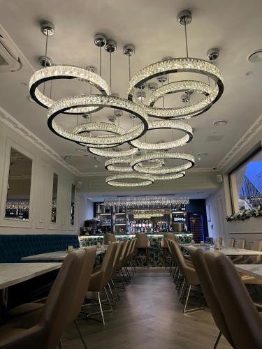 利物浦Philharmonic Hotel的用餐室配有桌椅和吊灯。