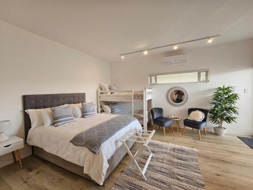 杰弗里湾Point Villa的一间卧室配有一张床、一张双层床和一张书桌。