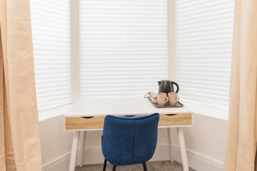 奥尔德姆Suite 1 - Lovely Ensuite in Oldham Sociable House的靠窗的一张桌子和一张蓝色椅子