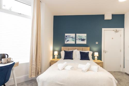 奥尔德姆Suite 1 - Lovely Ensuite in Oldham Sociable House的卧室配有白色大床和蓝色的墙壁