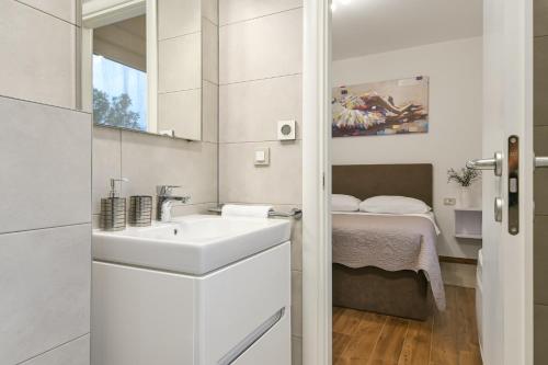 利纳迪奇Villa Aurea的白色的浴室设有水槽和一张床