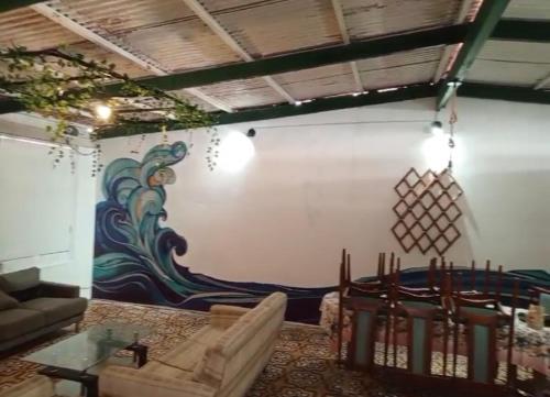 塔克纳Casa de playa de boca de río Primera fila - Playa planchon的客厅墙上有绘画作品