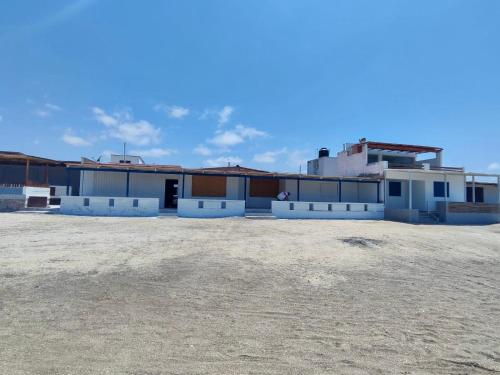 塔克纳Casa de playa de boca de río Primera fila - Playa planchon的建筑物旁边的一块地里的一组建筑物