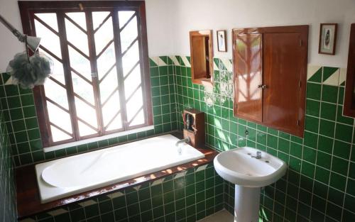 克鲁兹德华纳卡克斯特尔The Octopus's Garden Hostel的绿色瓷砖浴室设有浴缸和水槽