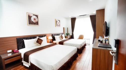 河内Lam Anh Hotel Dương Nội Hà Đông的酒店客房设有两张床和一台平面电视。