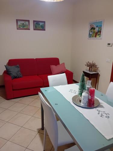 阿雷佐Casa rosa的客厅配有桌子和红色沙发