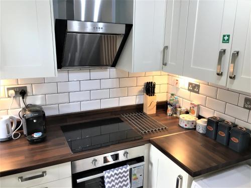 伦敦Newly Refurb Period 1-Bed Apartment with Roof Terrace, 47 sqm-500 sqft, in Putney near River Thames的厨房配有白色橱柜和炉灶烤箱。