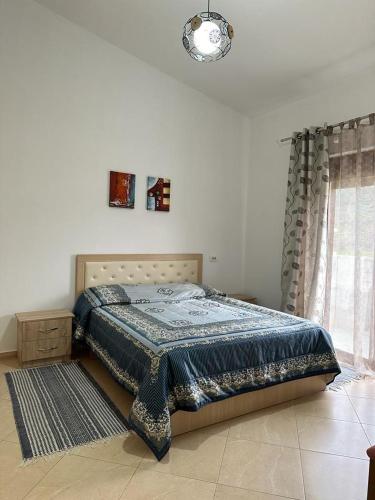 StalinAlbanian Gem in Kuçovë的一间卧室配有一张带蓝色毯子的床