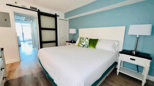 默特尔比奇Sea Watch Resort的卧室配有白色的床和蓝色的墙壁
