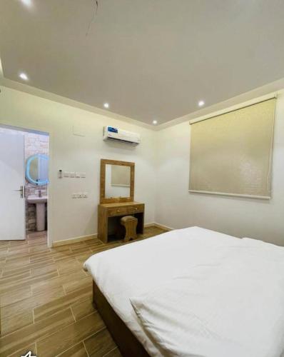 艾卜哈شاليهات الود的卧室配有白色的床和镜子