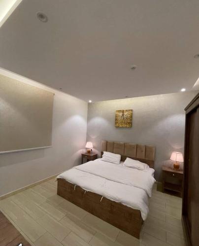 艾卜哈شاليهات الود的一间卧室配有一张大床和两张床头柜。