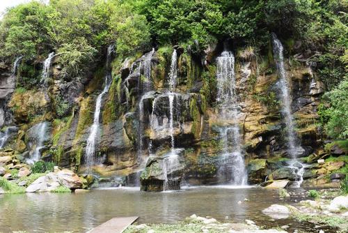 吉亚迪诺镇Casa V.Giardino pileta y cochera的山前的瀑布,有池塘