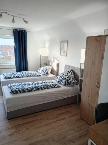 梅明根Ferienwohnung Allgäu 5的一间卧室配有两张带蓝白色枕头的床