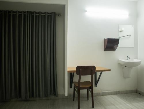 德里久尔Urban Oasis Homestay: AC Bedrooms的一间带书桌、水槽和卫生间的浴室