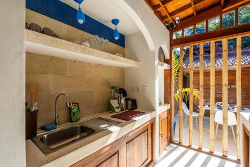 吉利阿尔Paradise Villa Gili Air的厨房设有水槽、窗户和桌子
