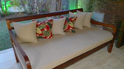 CamassariItacimirim Villas da Praia的一张木板凳,上面有许多枕头