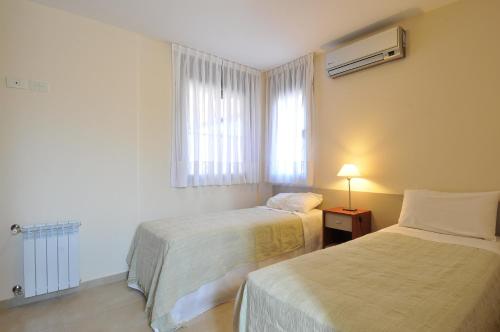 维拉卡洛斯帕兹AVIS Departamentos peatonal的酒店客房设有两张床和窗户。