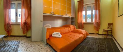 卡尔索利AL CAMPANILE centro storico ampio luminoso e panoramico appartamento trilocale的客房内的橙色床和毛巾
