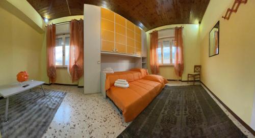 卡尔索利AL CAMPANILE centro storico ampio luminoso e panoramico appartamento trilocale的客厅配有橙色沙发和2扇窗户