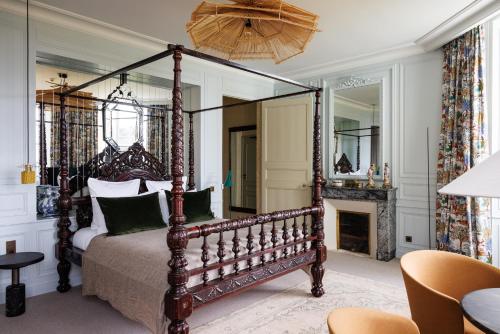 科尔维纳克Domaine de Locguénolé & Spa - Relais & Chateaux的一间卧室设有一张天蓬床和一个壁炉