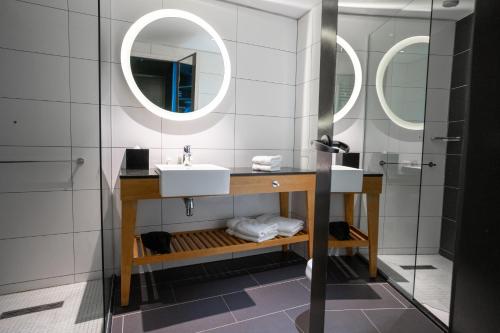圣卡洛斯-德巴里洛切Hampton By Hilton Bariloche的一间带水槽和两面镜子的浴室