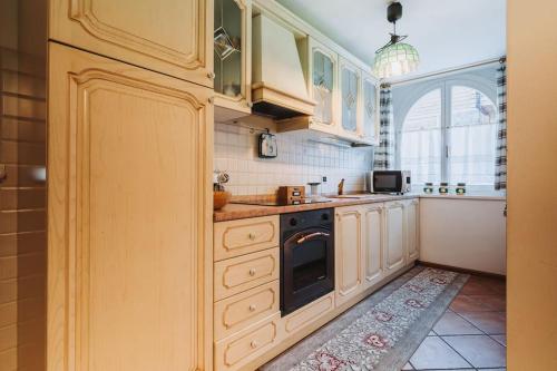 莫埃纳Il Rifugio di Dante - 10 Minuti dagli Impianti, Deposito e Parcheggio Privato的厨房配有白色橱柜和炉灶烤箱。