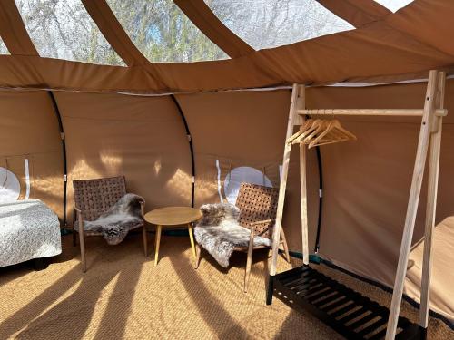 IdestrupRomantik Luxus Glamping 2的帐篷内带一张床和椅子的房间