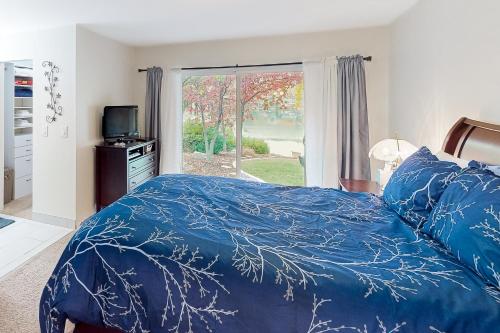 Lake Cortez Cottage的一间卧室配有一张带蓝色棉被的床和窗户。