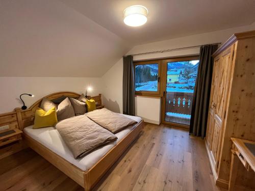 斯拉德明Haus Tennstein的一间卧室设有一张床和一个大窗户