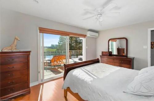 帕里桑德Waterfront, dream stay at Belle Vue Cottage的一间带床和镜子的卧室以及一个阳台