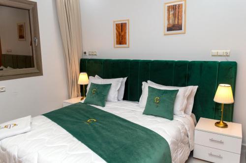 达赫拉Hotel Golden Sunset Dakhla的卧室配有带枕头的绿色和白色床。