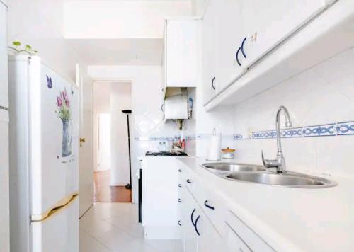 里斯本Rigoli Room的白色的厨房配有水槽和冰箱