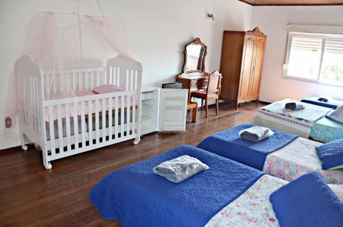 亚瓜龙Hotel rios rua uruguai n 99的一个带三张床和一张婴儿床的托儿所