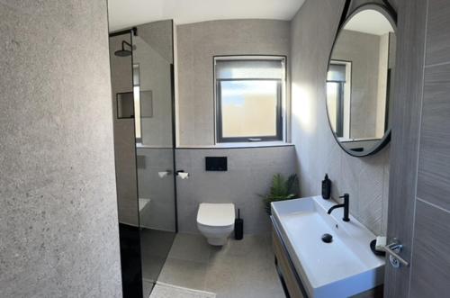斯图尔特港Seabreeze Cottage的一间带水槽、卫生间和镜子的浴室
