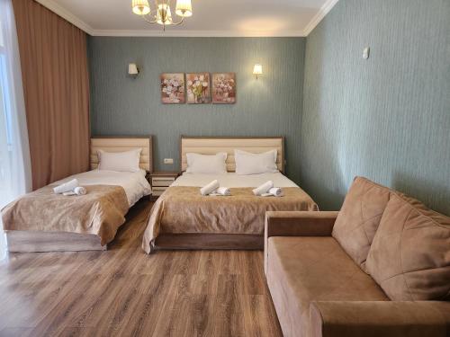 巴库里阿尼Snow King Hotel的酒店客房,设有两张床和一张沙发