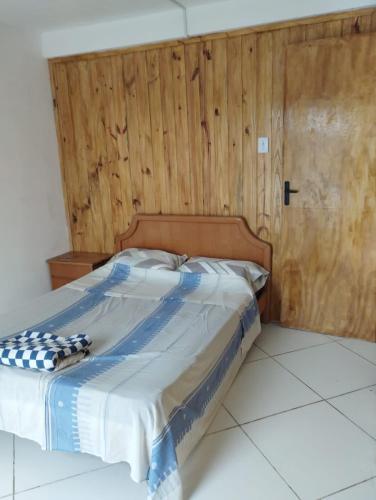 圣维多利亚-杜帕尔马Barra do chui Brasil的木墙客房的一张床位