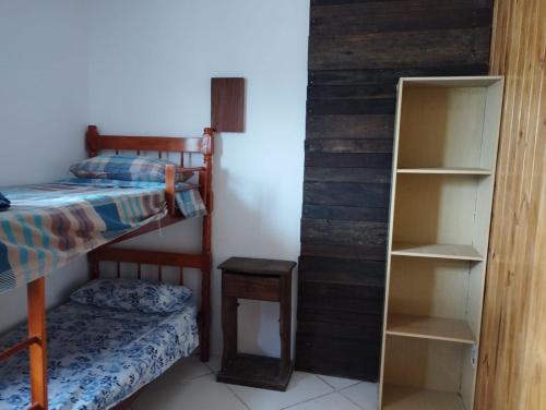 圣维多利亚-杜帕尔马Barra do chui Brasil的一间卧室配有双层床和书架