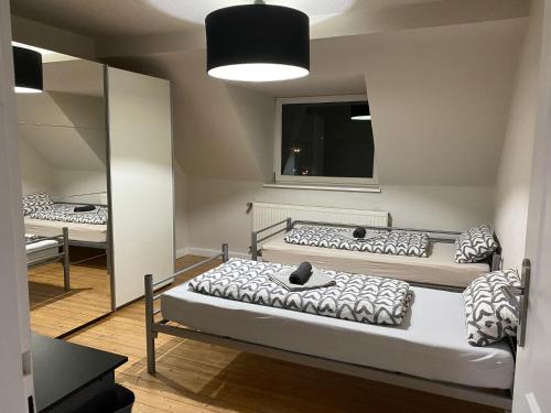 杜伊斯堡Duisburg FeelHome, Flughafen nah,2-Schlafzimmer, Badewanne, Zentral, WiFi, Top Floor的配有镜子的客房内的两张床