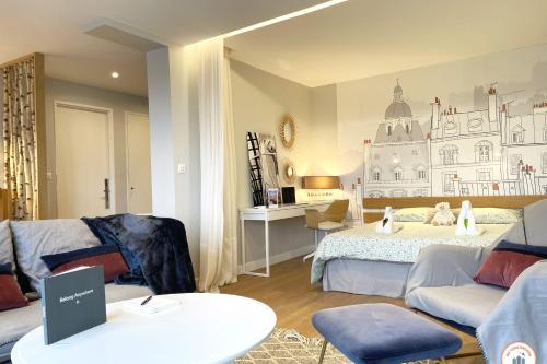 凯恩Entre Ciel et Terre - Vue Magnifique - Loft的一间卧室配有一张床、一张沙发和一张桌子