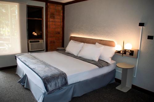 圣何塞Soy Local San José的一间卧室配有一张带白色床单的床和一扇窗户。