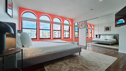 西棕榈滩The Lofts on Clematis 503 Downtown West Palm Beach的一间卧室设有一张大床,拥有红色的墙壁和窗户。