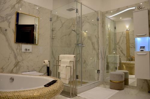 不来梅港Gemütliche Apartment Lucky und Lucky de Luxe的带浴缸和玻璃淋浴间的浴室。