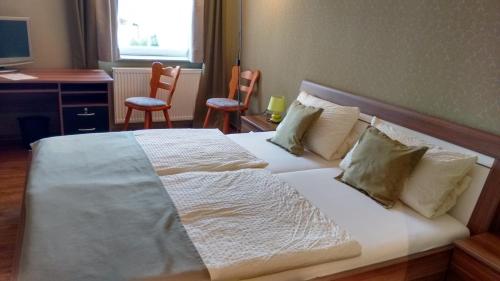 Holsthum奥贝比里格乡村民宿的卧室配有一张带两把椅子的白色大床